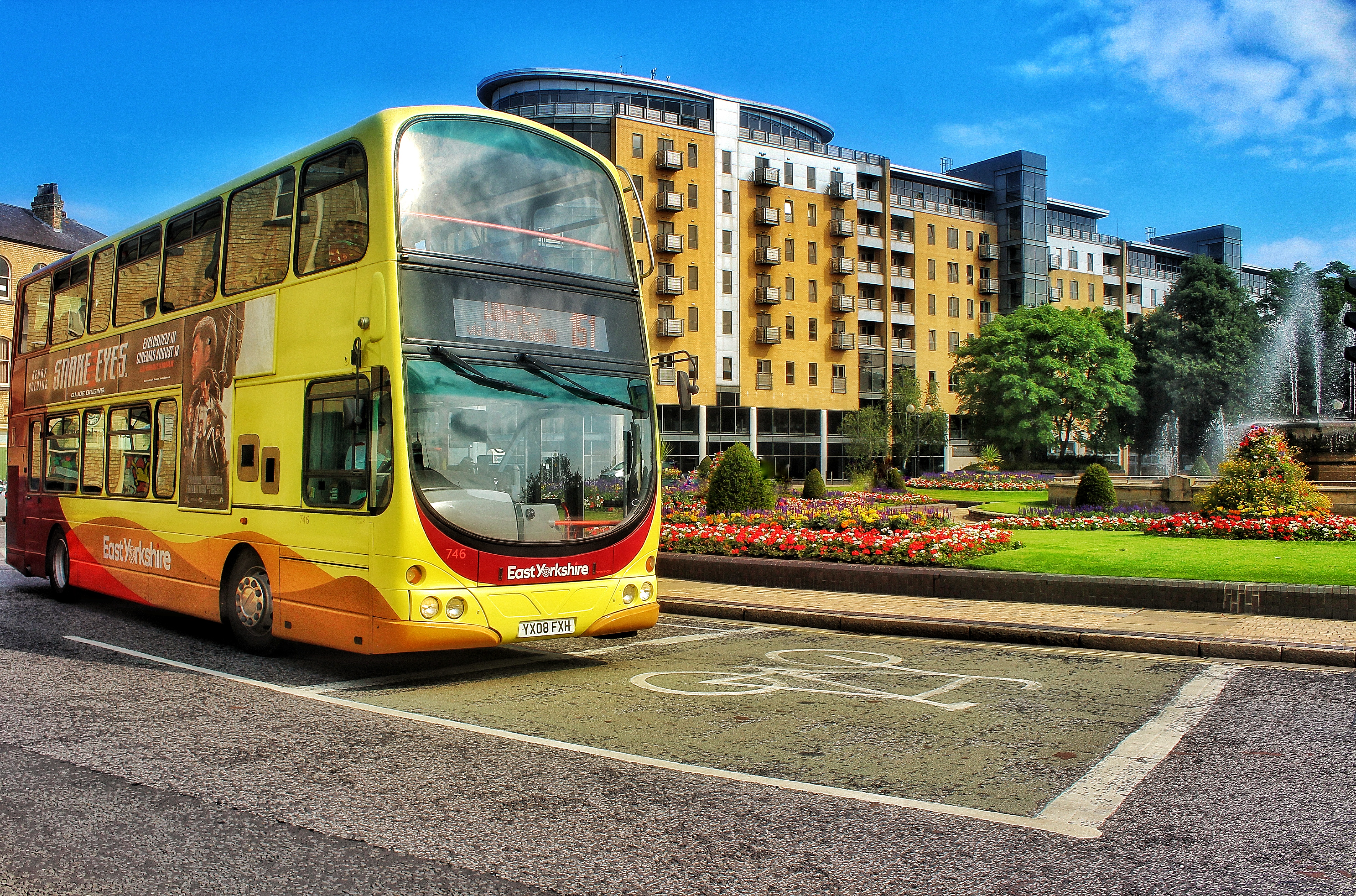 Yellow and red double decker bus in city centre