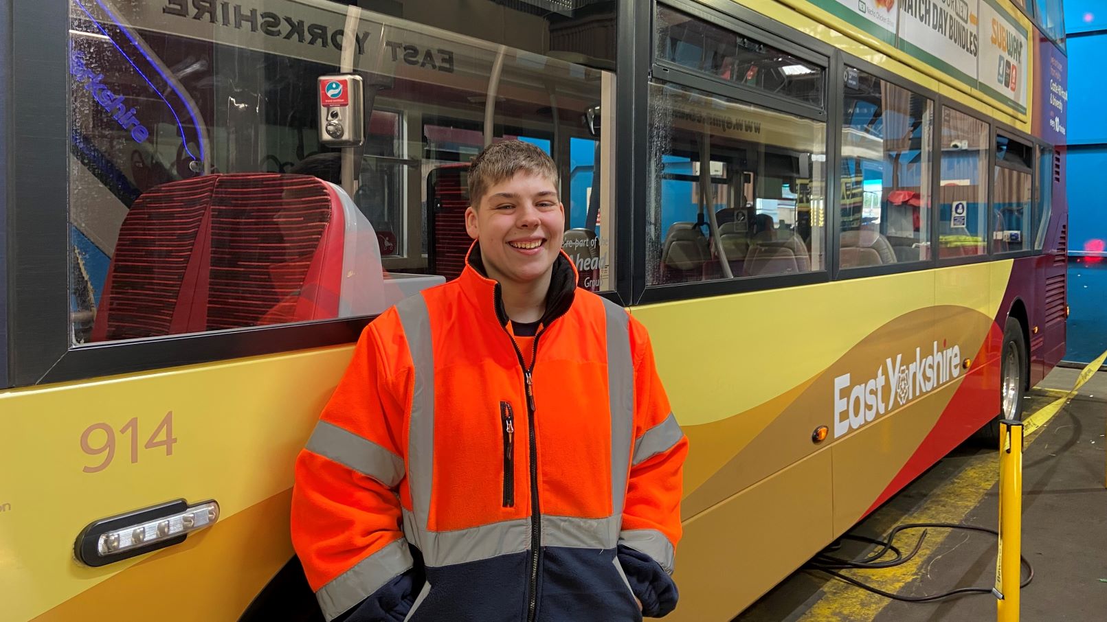 A picture of Jay Rodgers standing in front of an East Yorkshire bus